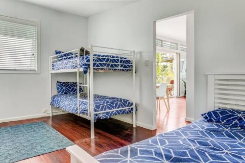 a bedroom with two bunk beds and a mirror at BEACHED @ YAMBA (water views, dog friendly, air con) in Yamba
