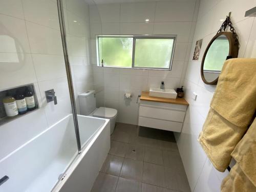 a bathroom with a tub and a toilet and a sink at Coastal Home, River & Surf Beach in New Brighton