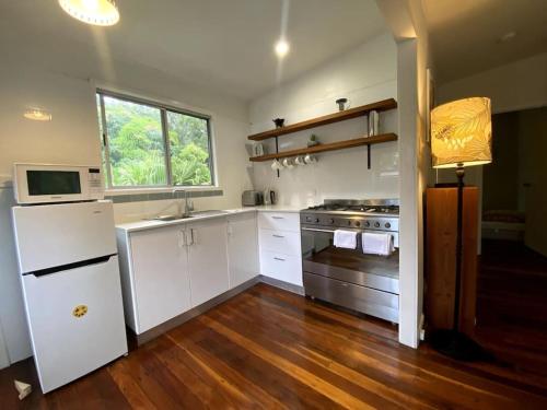 a kitchen with white cabinets and a stove and a window at Coastal Home, River & Surf Beach in New Brighton