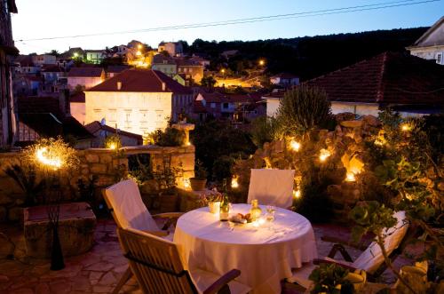 una mesa y sillas en un patio por la noche en Villa Moro House, en Milna