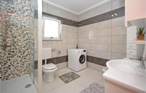 a bathroom with a toilet sink and a washing machine at Lovely Home In Vrgorac With Jacuzzi in Vrgorac