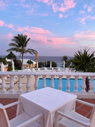 a white balcony with a table and a view of the ocean at Coco Reef Bermuda in Mount Pleasant