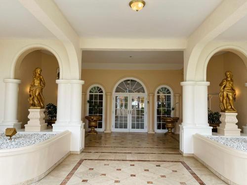 a lobby with two statues on columns and a door at Coco Reef Bermuda in Mount Pleasant
