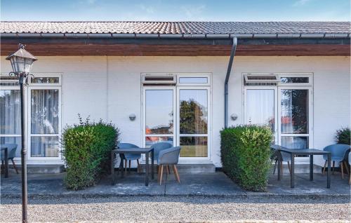 a group of tables and chairs in front of a building at Amazing Apartment In Allinge in Allinge