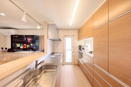 a kitchen with a sink and a tv on the wall at Crystal Besso Shirahama in Shirahama