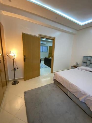 アガディールにあるGeil Wohnung in Agadir Zentrum Haut fountyのベッドルーム1室(ベッド1台付)、ドア付きのベッドルーム1室が備わります。