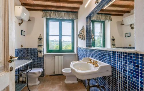 baño de azulejos azules con lavabo y aseo en Il Maraldo en Schifanoia