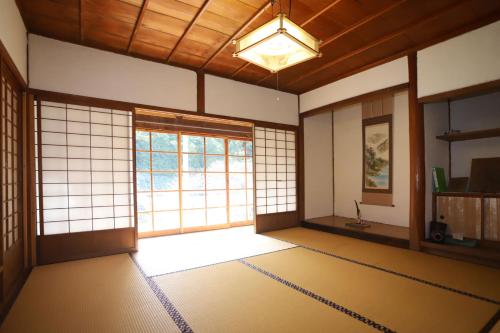 an empty room with a large window in a japanese room at Kamenarien in Ema