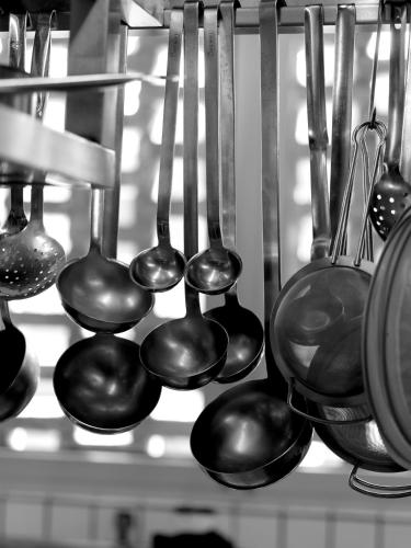 a group of spoons and utensils hanging on a shelf at Relais & Châteaux Taubenkobel in Schützen am Gebirge