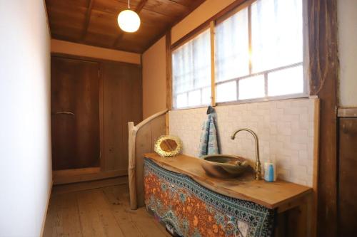 una cucina con lavandino in legno e finestra di Kamenarien a Ema
