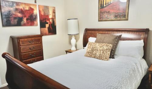 a bedroom with a bed and a lamp and paintings at University Home-near U Of U, Hospitals, Downtown in Salt Lake City