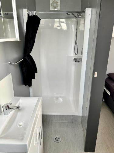 a white bathroom with a shower and a sink at Leichhardt Accommodation in Moranbah
