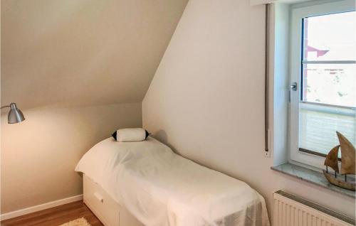 a small bed in a corner of a room with a window at Windrose in Gollwitz