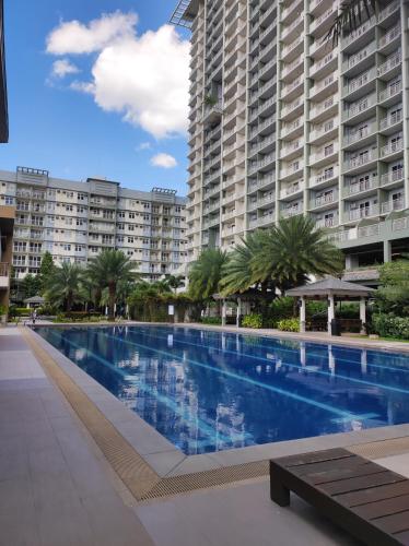 a large swimming pool in front of a large building at COZY PLACE TO RELAX VERDON PARC in Davao City