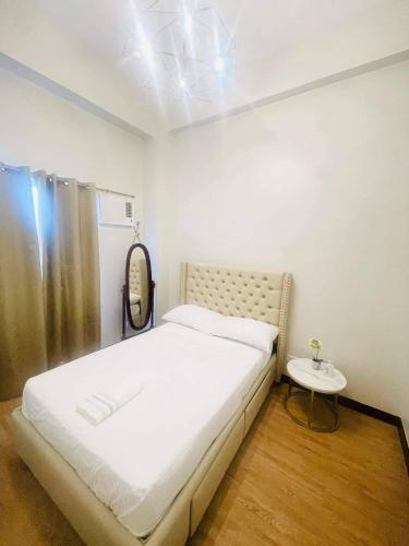 a bedroom with a bed with a mirror and a table at COZY PLACE TO RELAX VERDON PARC in Davao City