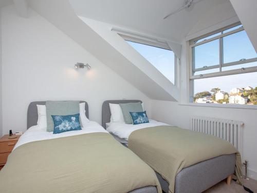 twee bedden in een kamer met een raam bij The Lookout 43 in Brixham