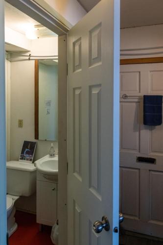a bathroom with a sink and a toilet and a door at Meadow Suites in Wells in Barkerville