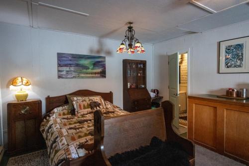 a bedroom with a bed and a chandelier at Meadow Suites in Wells in Barkerville