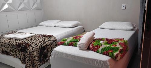 two beds in a small room withskirts at Pousada Status Jalapão in Mateiros