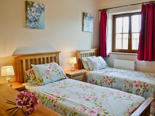 two beds in a bedroom with red curtains at The Mill - Om3 in Mydroilin