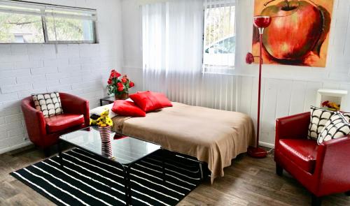 1 dormitorio con 1 cama y 2 sillas rojas en University Stay-near U Of U, Hospitals, Downtown, en Salt Lake City