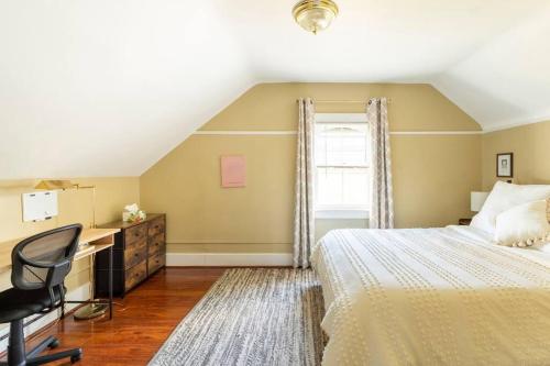 Un dormitorio con una cama, un escritorio y una silla. en Artist retreat near all Rochester sites, en Rochester