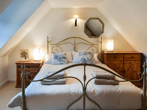 a bedroom with a large bed and a mirror at Oakwood Cottage in Glencoe