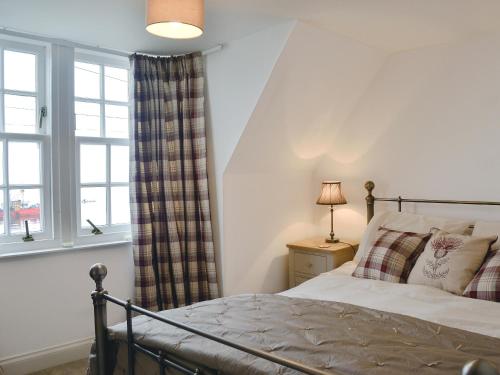 1 dormitorio con cama y ventana en Raglan Cottage, en Ardentinny