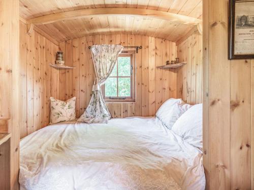 een slaapkamer met een wit bed in een houten kamer bij The Kingfisher - Uk40298 in Martin
