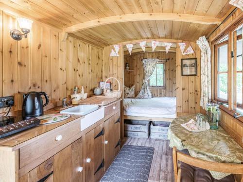 uma cozinha com um lavatório e uma cama num quarto em The Kingfisher - Uk40298 em Martin