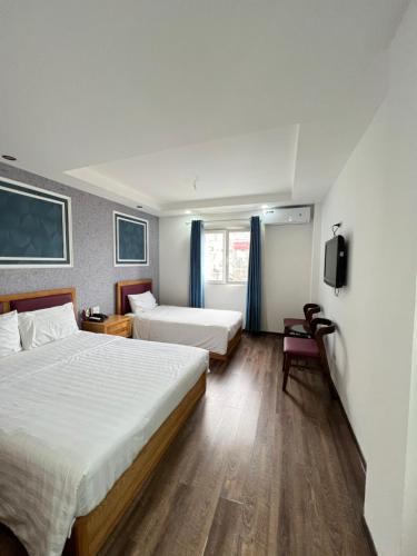 a hotel room with two beds and a tv at Holiday Suites Hotel & Spa in Hanoi