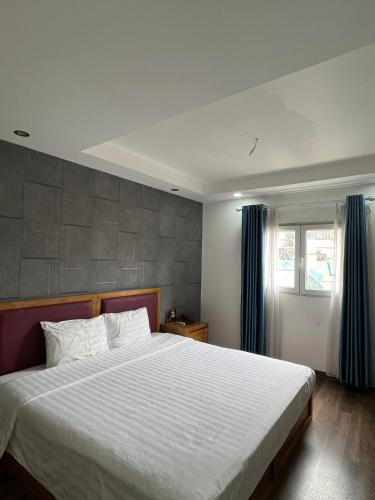 a bedroom with a large bed and a window at Holiday Suites Hotel & Spa in Hanoi