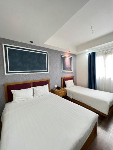 Holiday Suites Hotel & Spa في هانوي: غرفة فندقية بسريرين ونافذة