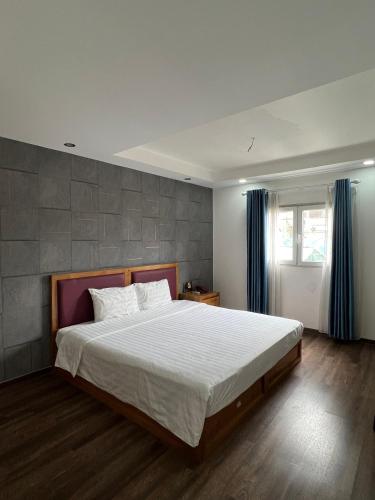 a bedroom with a large bed and a window at Holiday Suites Hotel & Spa in Hanoi