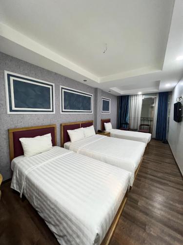 a hotel room with two beds in a room at Holiday Suites Hotel & Spa in Hanoi