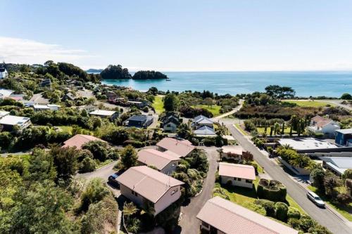 an aerial view of a village with the ocean in the background at Unit 1 Kaiteri Apartments and Holiday Homes in Kaiteriteri
