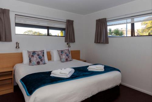 a bedroom with a bed with two towels on it at Unit 1 Kaiteri Apartments and Holiday Homes in Kaiteriteri