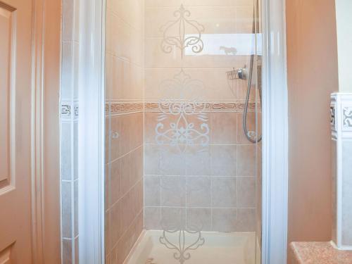 a bathroom with a shower with a glass door at The Palms in Seasalter