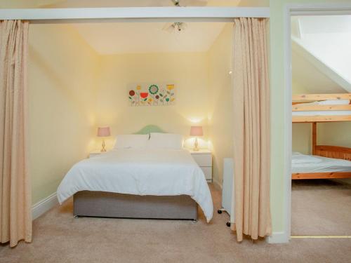 a bedroom with a large white bed with two lamps at Apartment Fourteen - Uk39870 in Paignton