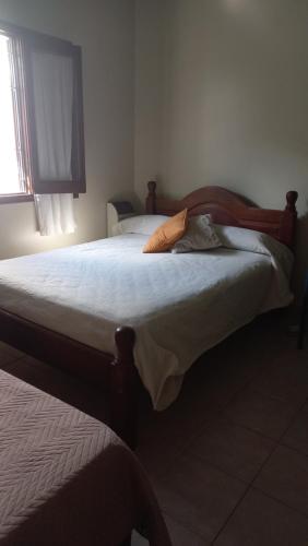 duże łóżko w sypialni z oknem w obiekcie Chalet del Rosedal w mieście San Salvador de Jujuy