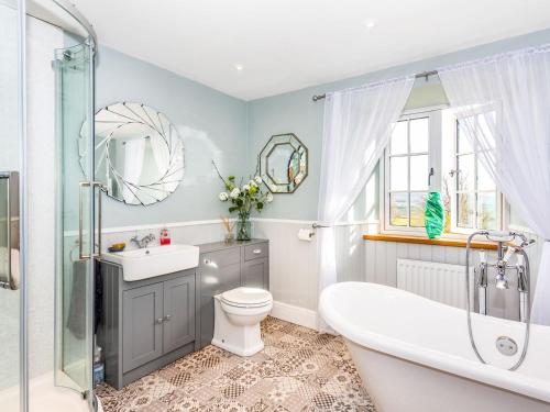 a bathroom with a tub and a toilet and a sink at The Farmhouse - Uk33419 in West Witton