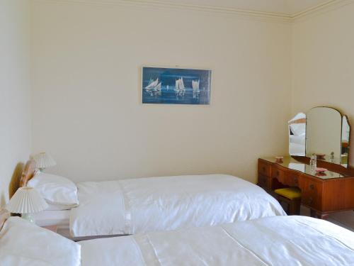 a hotel room with two beds and a desk with a mirror at Ardmore in Largs