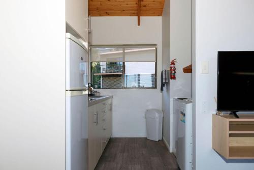 cocina con nevera y fregadero en Unit 2 Kaiteri Apartments and Holiday Homes, en Kaiteriteri