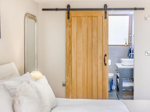 a bedroom with a wooden door and a sink at The Old Workshop in Broom