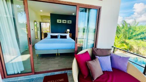 a bedroom with a bed and a couch on a balcony at Canal Village Pakpra Phatthalung in Phatthalung
