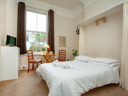 a bedroom with a large white bed and a window at Apartment One - Uk39832 in Paignton