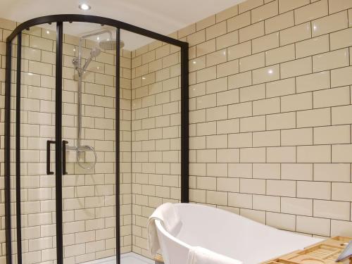 a bathroom with a tub and a glass shower at Warrington House in Tideswell