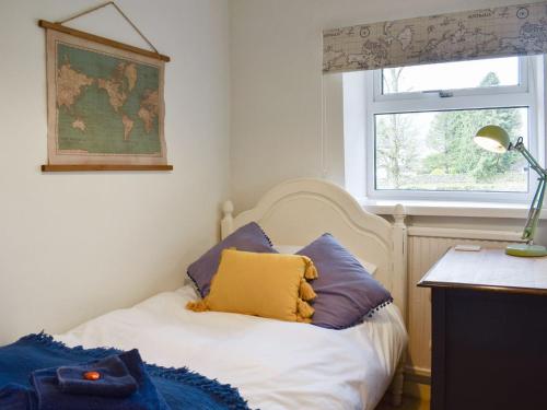 ein Schlafzimmer mit einem Bett mit lila und gelben Kissen in der Unterkunft Number 3 - Uk33333 in Newby