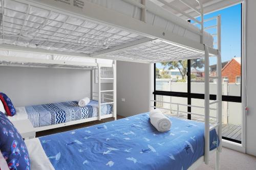 a bedroom with two bunk beds and a balcony at Birdland in Port Fairy