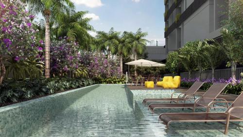 una piscina con sillas, sombrilla y palmeras en Apartamento Premium em Pinheiros, en São Paulo